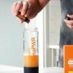 Wellness Spas - A man is preparing orange juice in a blender