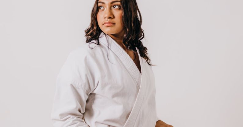 Student Discounts - A woman in a white karate uniform holding a red belt