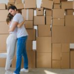 Couples' Packages - Man and Woman Hugging Near the Pile of Boxes