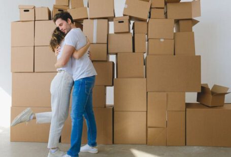 Couples' Packages - Man and Woman Hugging Near the Pile of Boxes