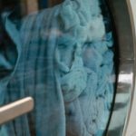 Laundry Services - Blue Towels in a Front Load Washing Machine