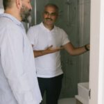 Long-Term Rental - Two Men Looking Into a Bathroom