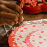 Romantic Spots - Black man making decorations for Saint Valentine Day