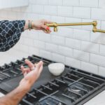 Amenities - A Person Holding a Brass Faucet Tube
