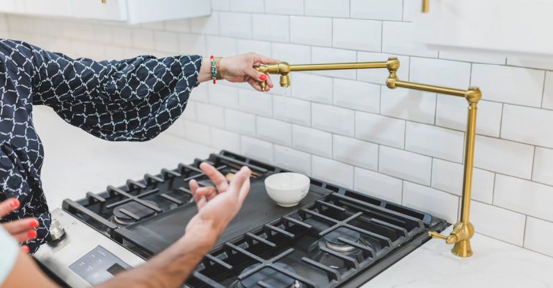 Amenities - A Person Holding a Brass Faucet Tube