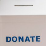 Benefits - Crop anonymous person showing donation box